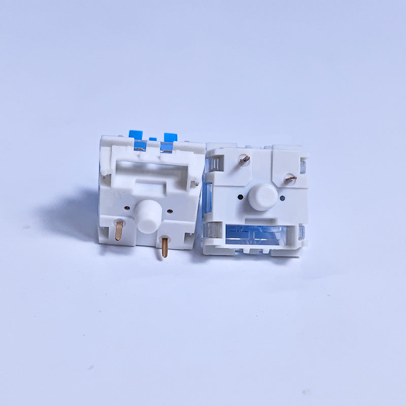 Clickzen – Two white and clear switches with blue stems, side by side from the front, showing gold pins