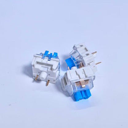 Clickzen – Three white switches with clear housings and blue stems, arranged at different angles on a white background
