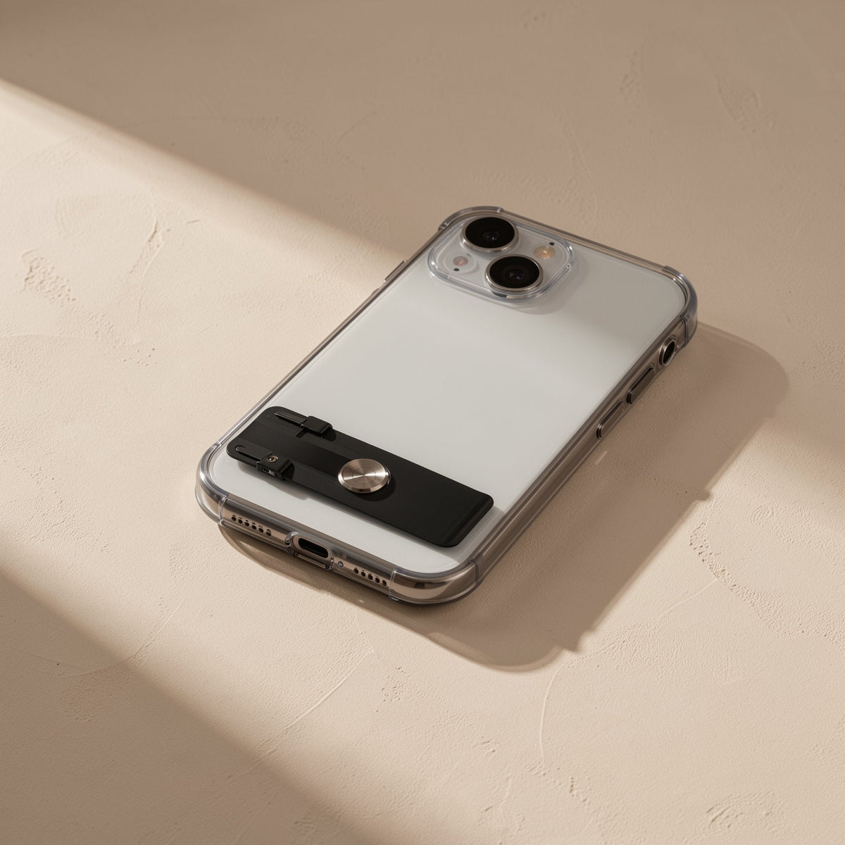 Spinstand – Folded black stand with round metal disc attached flat to the back of a clear-cased phone