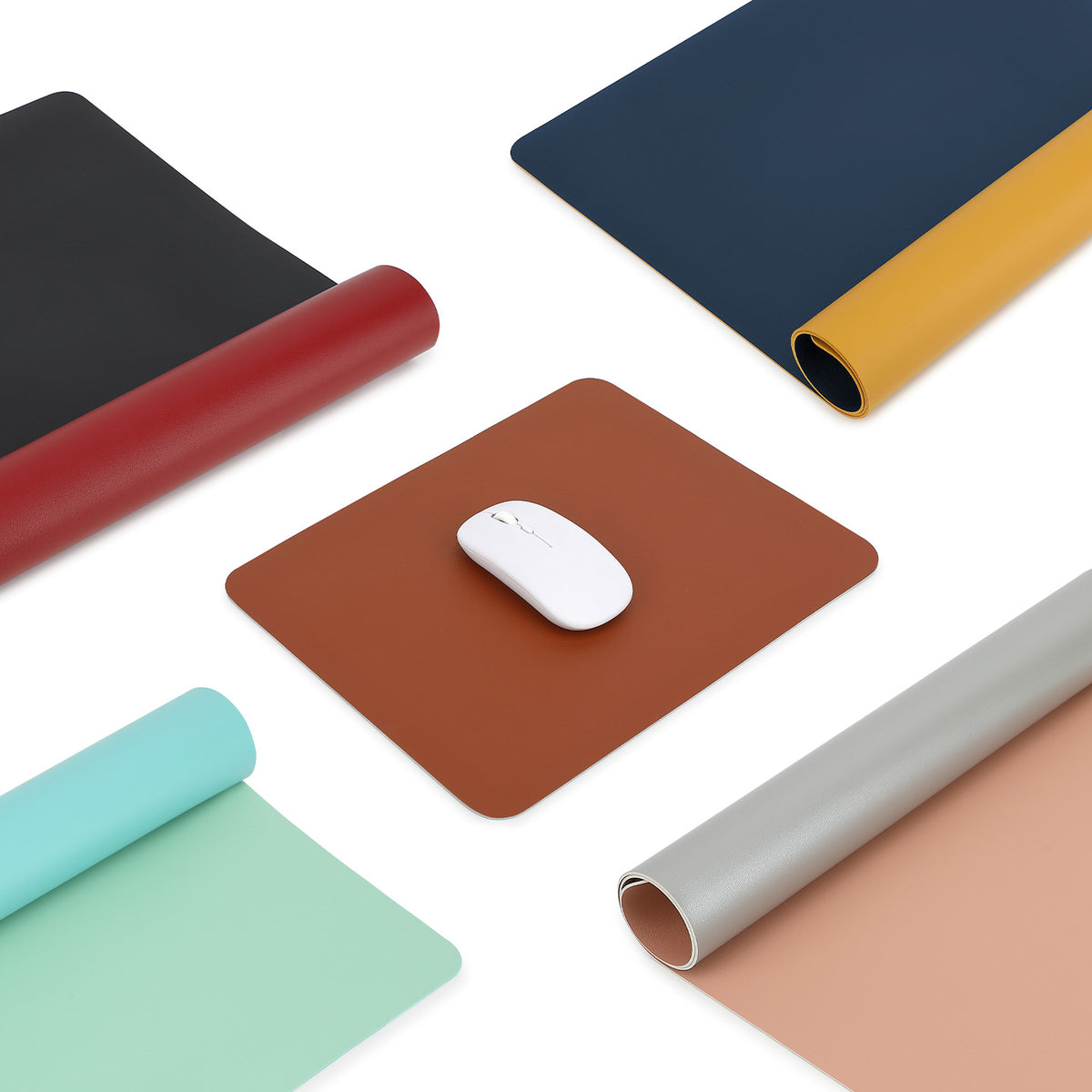 Dualhide – Desk mats in brown, navy and yellow, black and red, mint and green, and grey and pink, some rolled