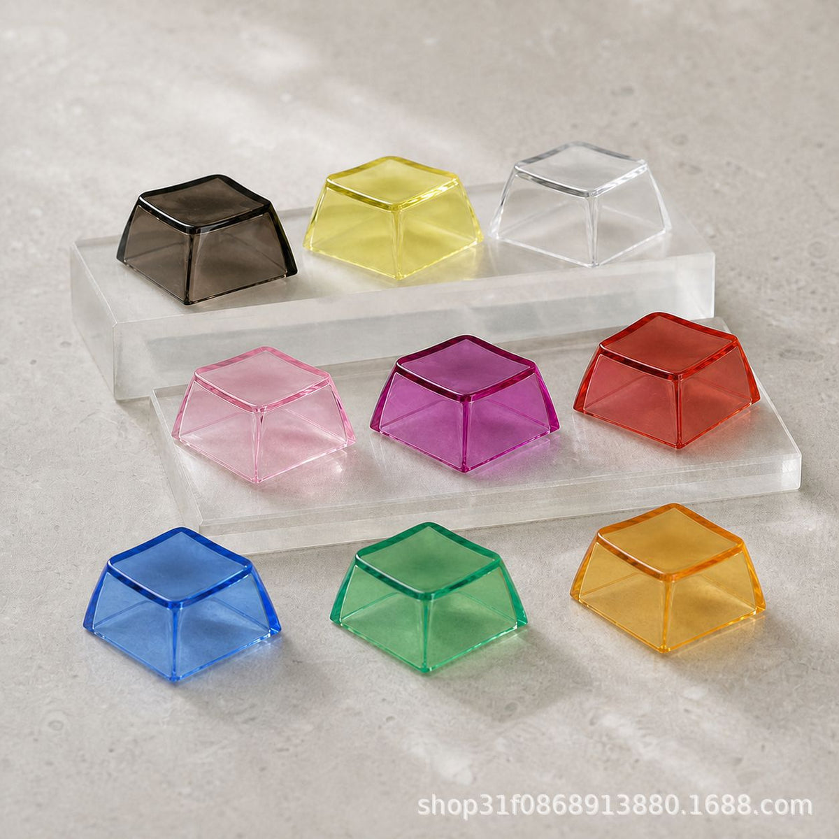 Clarion – Nine translucent keycaps in black, yellow, clear, pink, purple, red, blue, green and amber on clear acrylic stands
