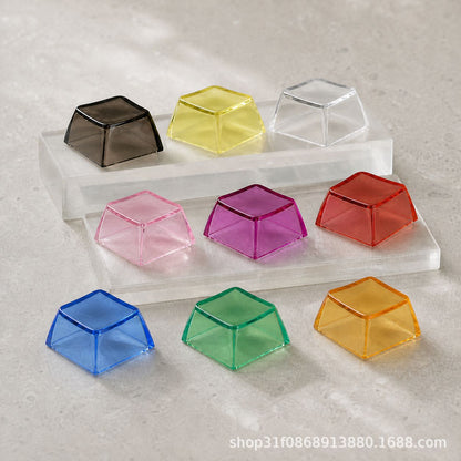 Clarion – Nine translucent keycaps in black, yellow, clear, pink, purple, red, blue, green and amber on clear acrylic stands