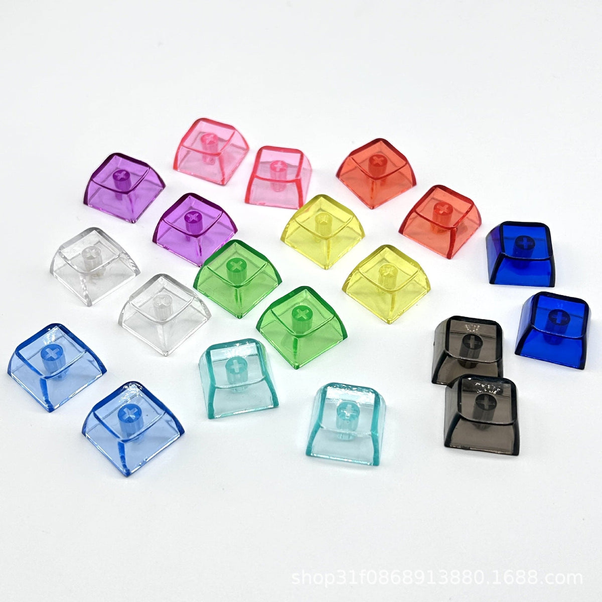 Clarion – Overhead view of assorted translucent keycaps tilted to show the cross-shaped stem sockets on a white background