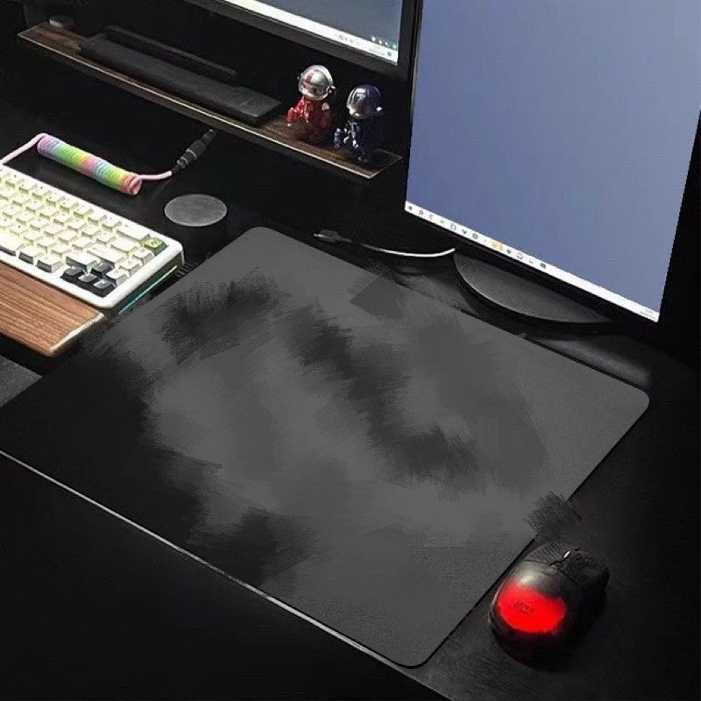 Padhold – Dark gray brush-pattern desk mat on a gaming desk with a keyboard, monitor and a mouse with red glowing light