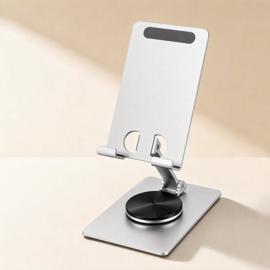 Spinperch – Silver aluminum phone stand with a rectangular base, black rotating disc and slot cutouts on a cream backdrop