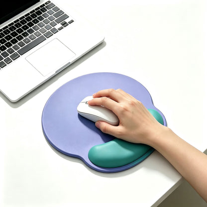 Dualhue – Hand using a white mouse on the purple pad, wrist resting on the green cushion, laptop beside it