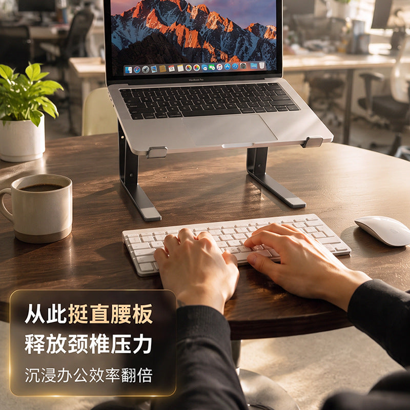 Loftvent – Laptop on a dark stand at a wooden table, hands typing on a white keyboard, coffee mug and plant nearby