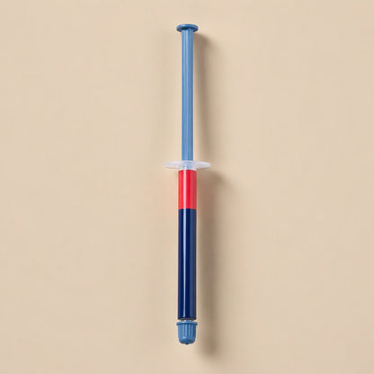 Chipglide CPU Thermal Paste – slim syringe with blue plunger, red band and navy barrel standing upright on a peach background