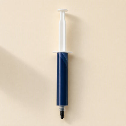 Chipglide – Wider-barrel navy syringe with white plunger and black tip cap, viewed from above on a beige surface