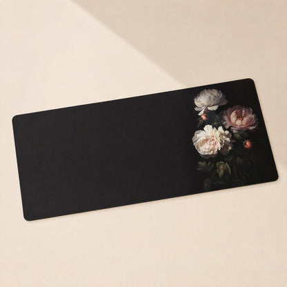 Gripdesk Rubber Desk Mat in black with pink and white peonies on the right, angled view on a cream surface