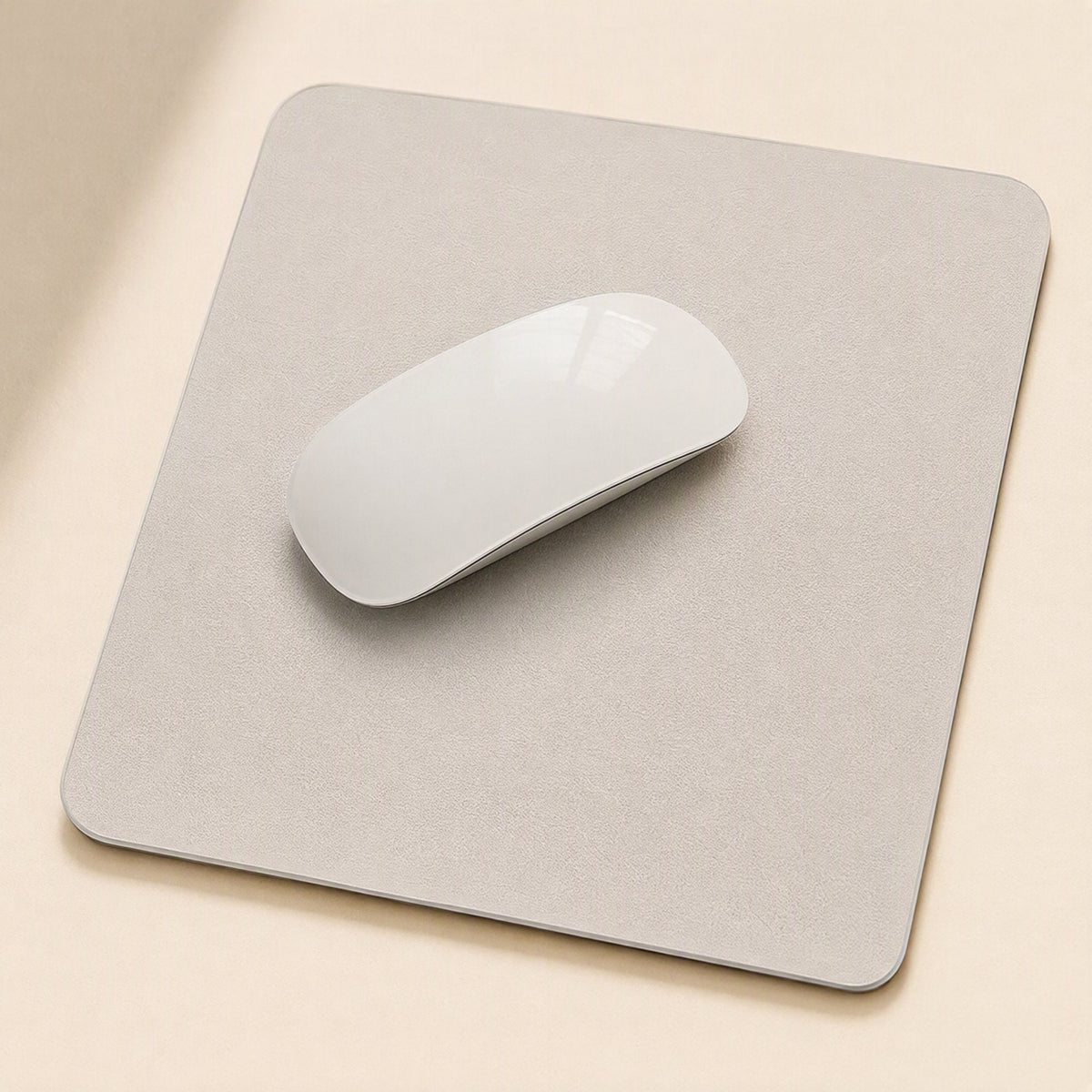 Gripdesk – Light grey square mouse pad with a white wireless mouse on top, seen from above on a beige desk