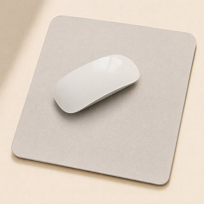Gripdesk – Light grey square mouse pad with a white wireless mouse on top, seen from above on a beige desk
