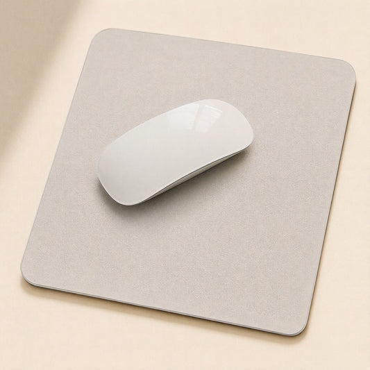 Gripdesk – Light grey square mouse pad with a white wireless mouse on top, seen from above on a beige desk