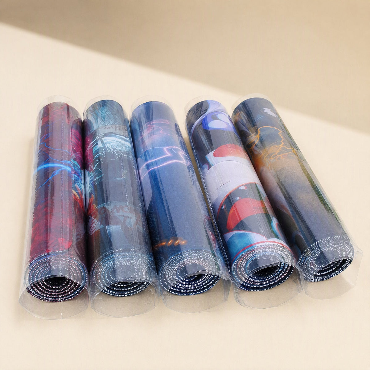Gripdesk – Five rolled-up mouse pads in clear plastic sleeves, each with a different colorful printed design