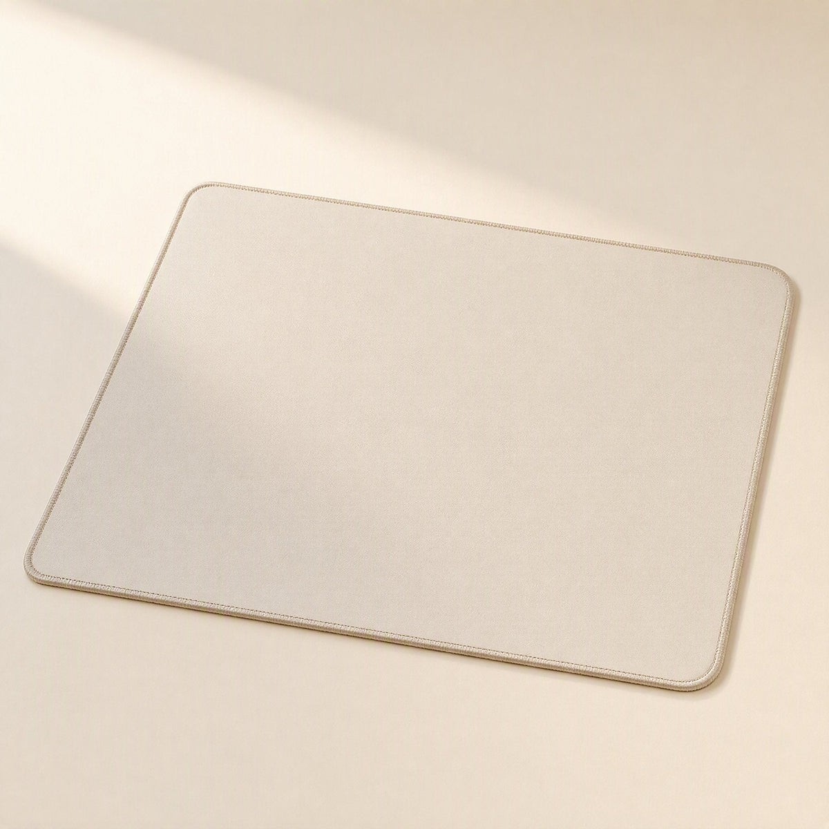 Gripdesk – Beige square mouse pad with stitched edges and rounded corners, shown flat on a cream surface