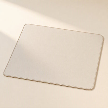 Gripdesk – Beige square mouse pad with stitched edges and rounded corners, shown flat on a cream surface