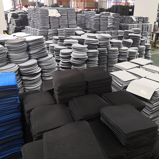 Deskanchor Non-Slip Mouse Pad for Desk – warehouse floor stacked with piles of black, gray, blue and white mouse pad blanks