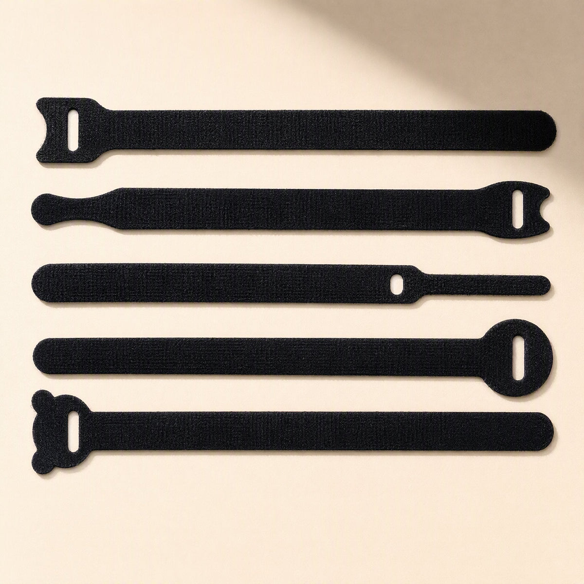 Loopstem – Five black hook-and-loop ties with different end shapes, including rounded and bear-ear tips, laid flat