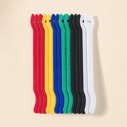 Loopstem – Row of upright hook-and-loop ties in red, yellow, blue, green, black and white standing side by side