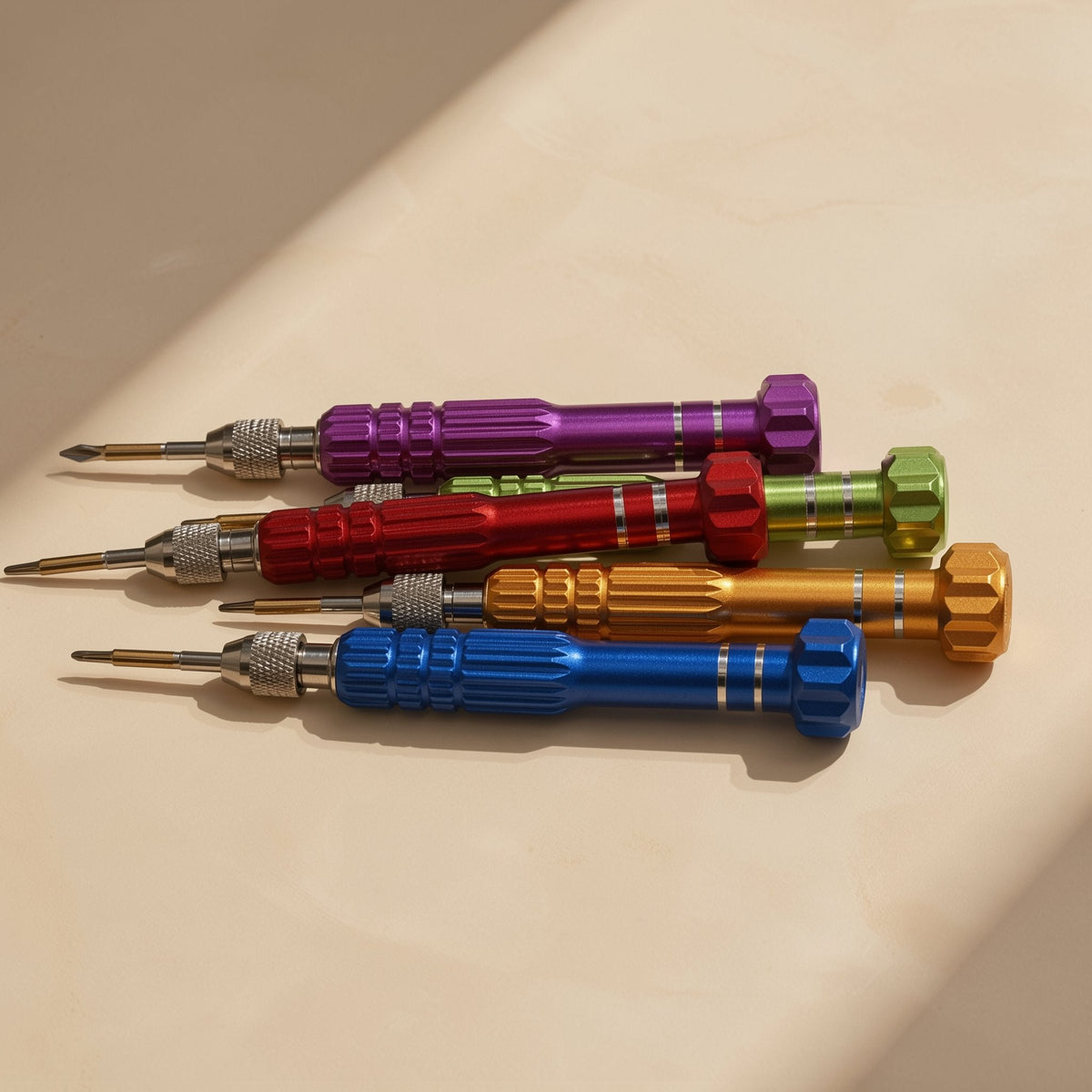 Screwwise – Five colorful knurled-handle screwdrivers laid in a stack, tips pointing left, on a light wood surface