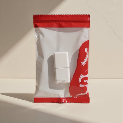 Cardport – White USB card reader in a clear zip pouch with a red band, seen from above, with sunlight and shadow