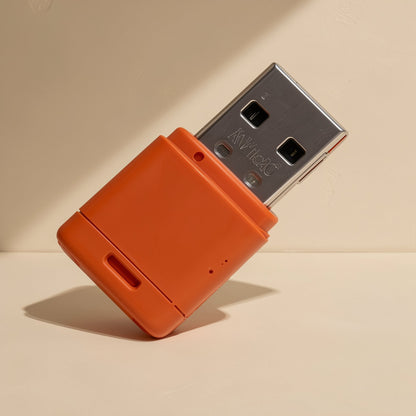 Cardport USB TF Card Reader – orange USB card reader with metal plug and small slot, tilted upright against a beige backdrop