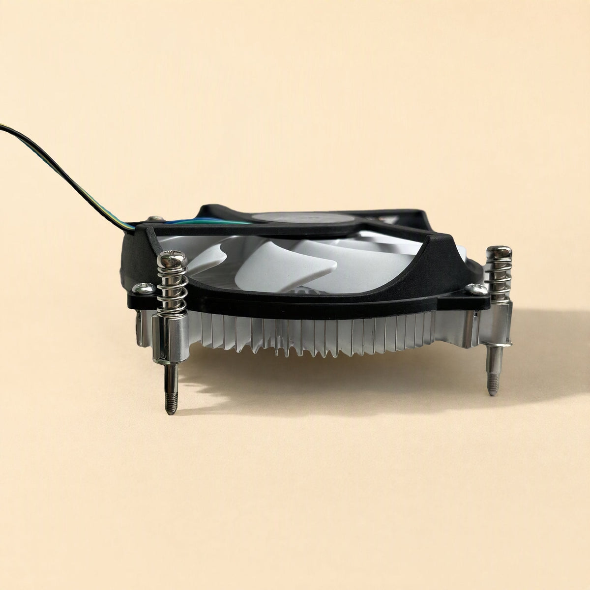 Slimchill – Side view of the low-profile cooler with black fan frame, coiled springs and screws on a beige background