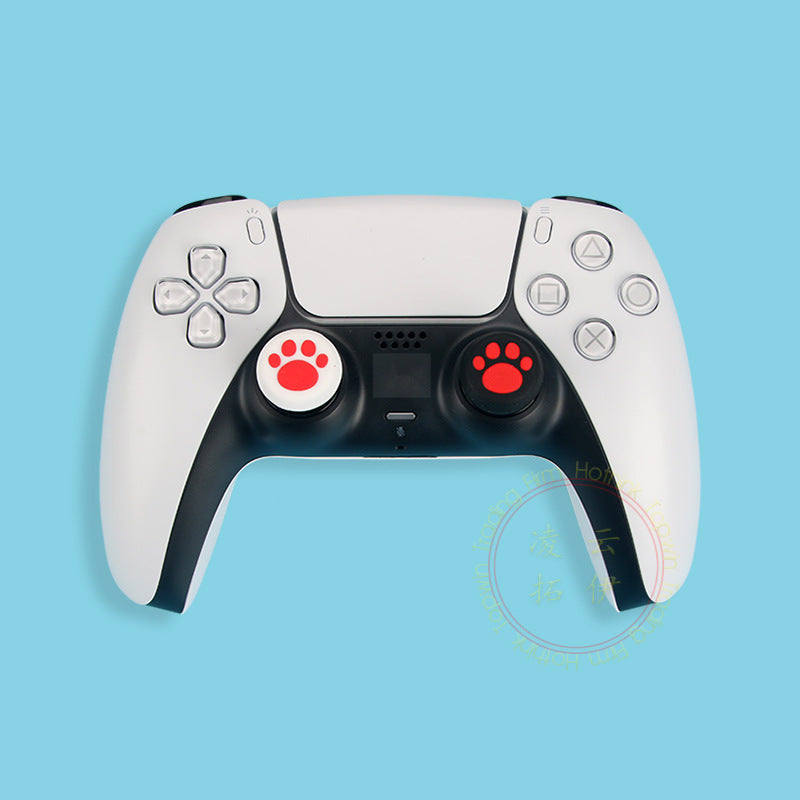 Pawgrip – PS5 controller fitted with red paw-print thumbstick grips, one white and one black, on a blue backdrop