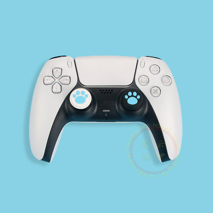 Pawgrip – Pair of light blue paw-print joystick caps, white and black, fitted on a white PS5 controller