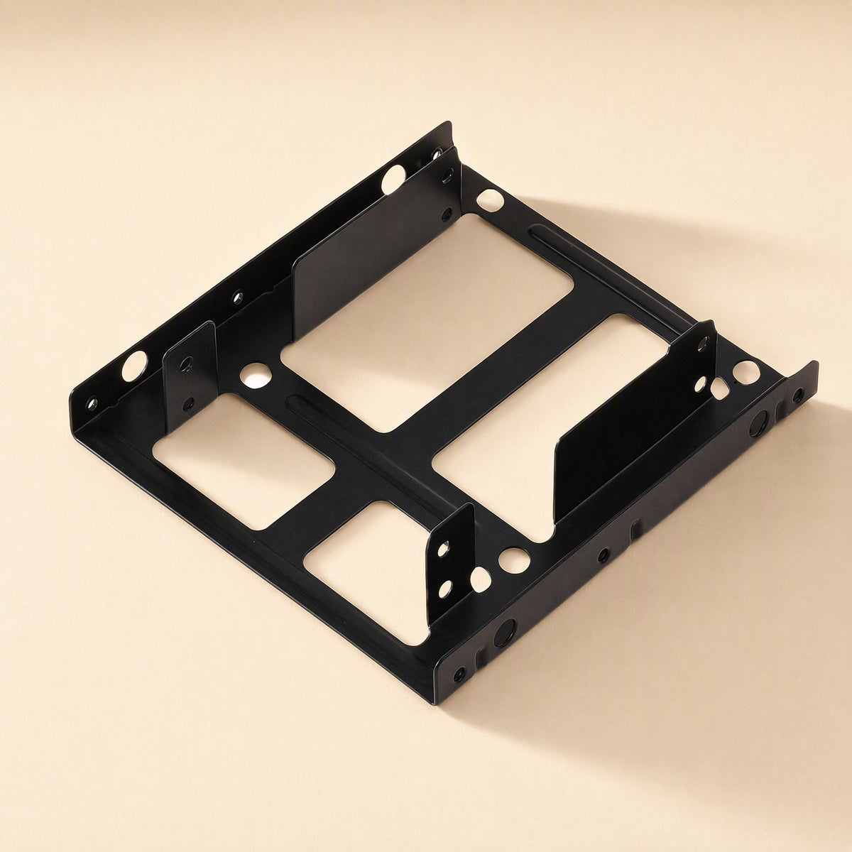 Drivehold Desktop Hard Drive Bracket, black metal, shown from a high front angle on a cream background