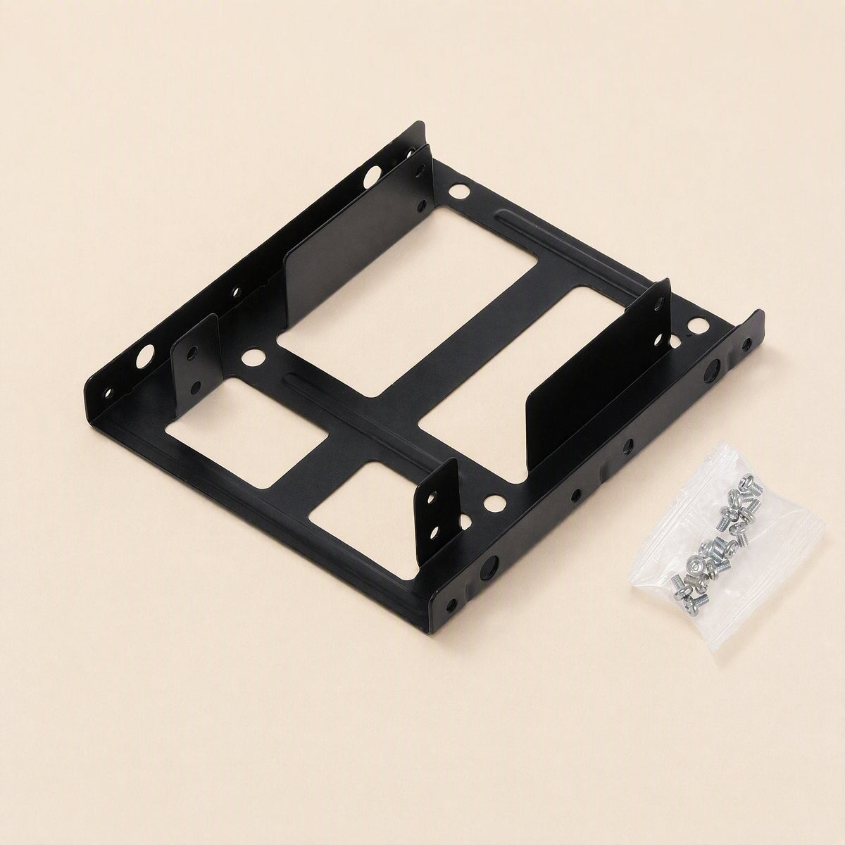 Drivehold – Black metal bracket with a small clear bag of silver mounting screws beside it on a cream surface