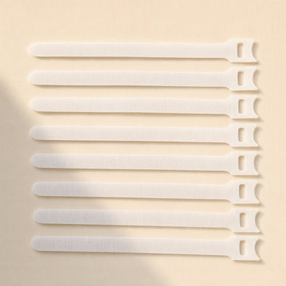 Loopmate – Eight white hook-and-loop cable ties lined up in a neat row on a cream background