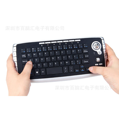 Keytrail – Hands holding the compact wireless keyboard, trackball at top right and a watermark across the photo