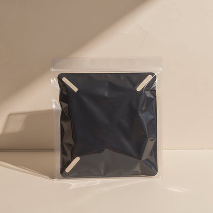 Wallpivot – Black monitor wall mount sealed in a clear zip bag with small tape labels, on a cream surface