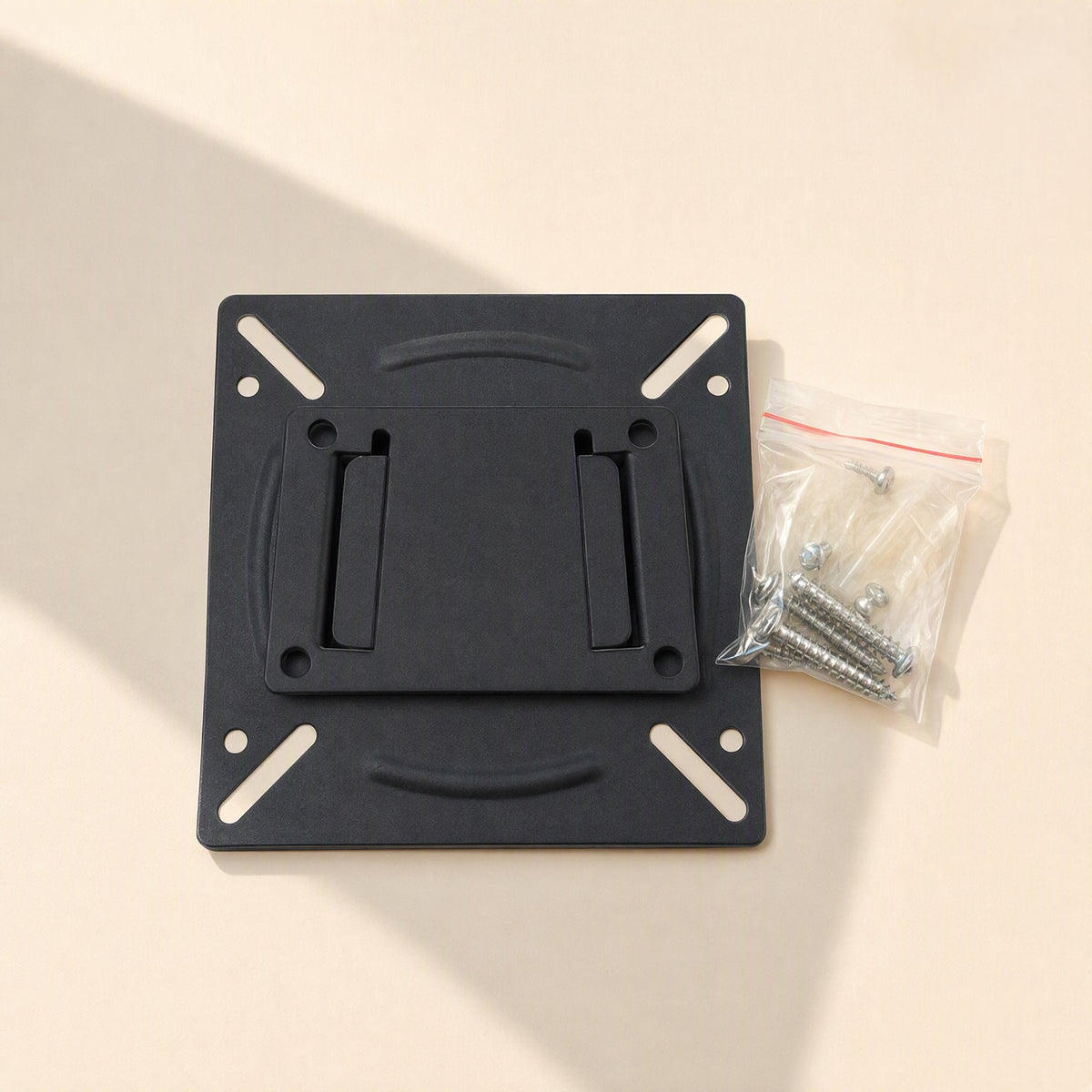 Viewbrace – Monitor wall mount bracket laid flat beside a clear bag of mounting screws on a beige surface