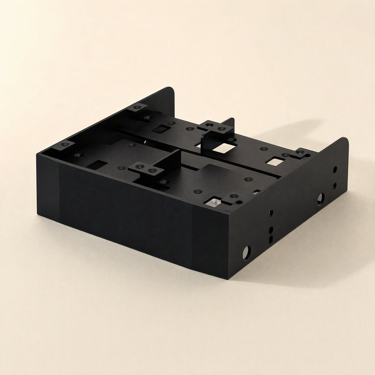 Baybridge – Empty black metal bracket from above, showing mounting tabs, screw holes and cutouts, no drives installed