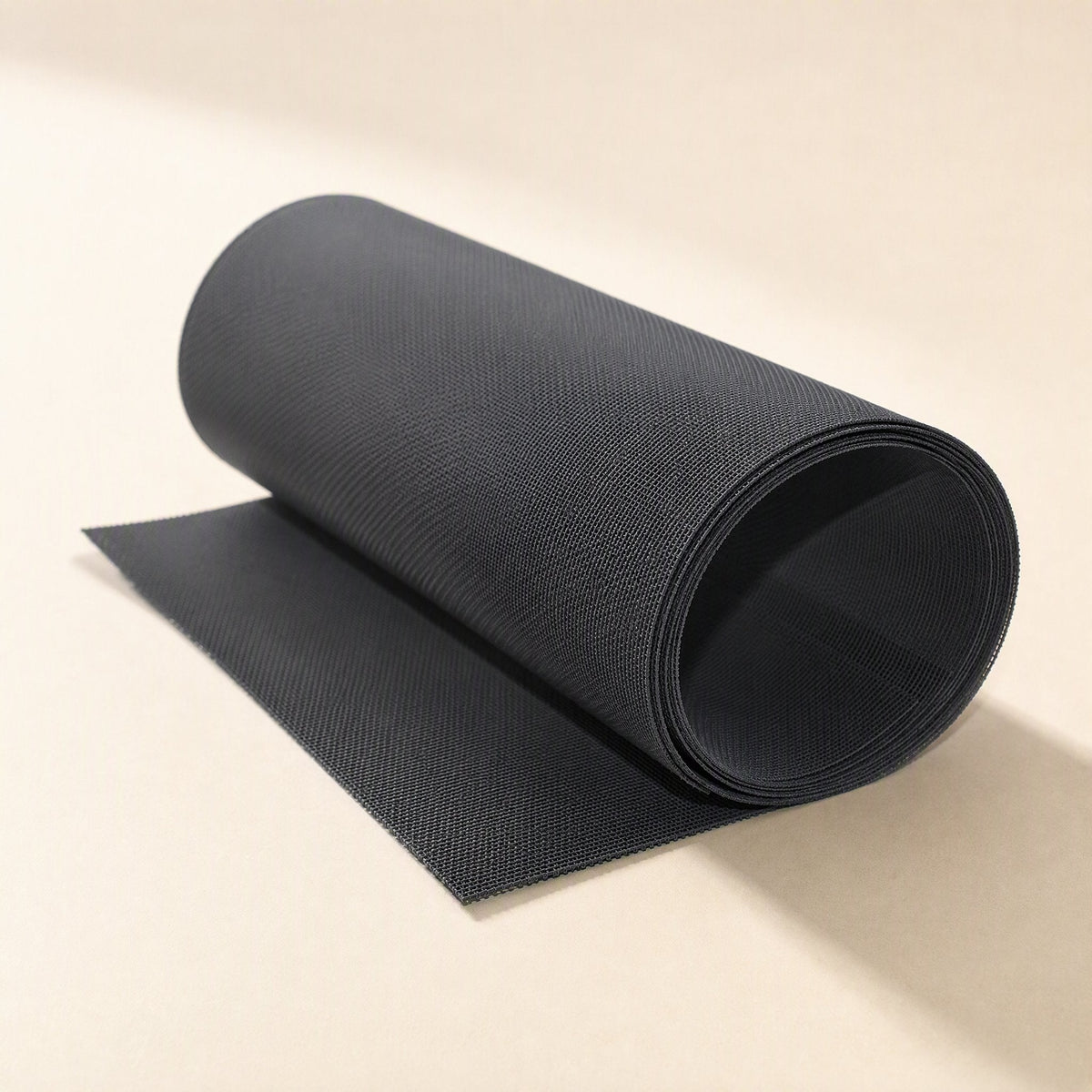 Fanfilter PVC Chassis Fan Dust Filter Mesh in black, rolled up with one end unrolled on a cream background