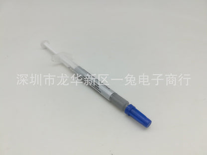 Thermend Silver Silicone Thermal Paste syringe lying diagonally with blue cap and gray label on white background