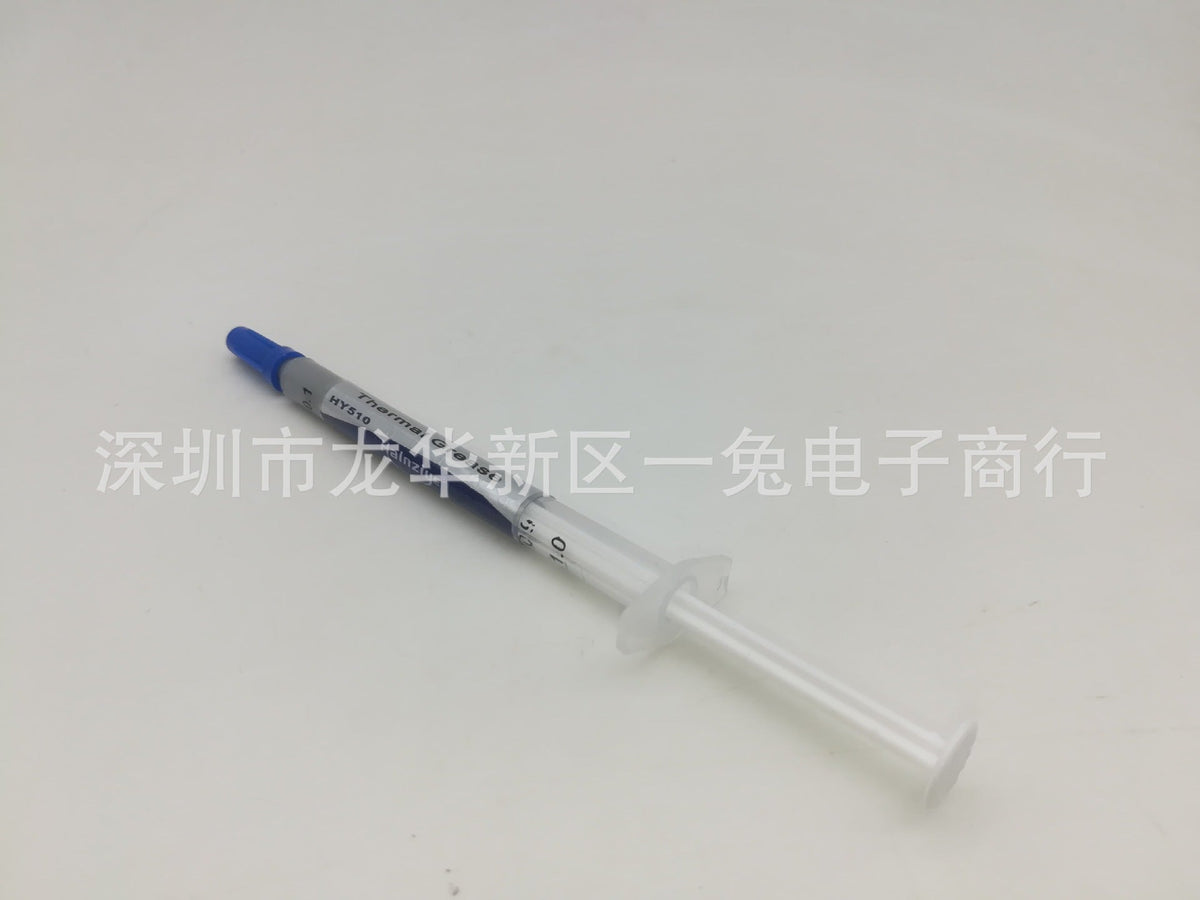 Thermend – Thermal paste syringe viewed from plunger end, clear barrel and white plunger flange, blue cap at top left