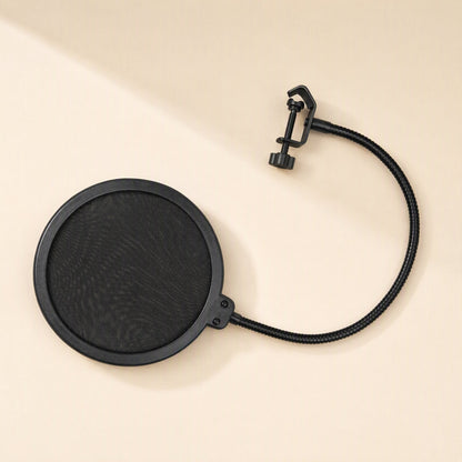 Popmesh – Black pop filter with a curved gooseneck arm and screw clamp, laid flat on a cream surface
