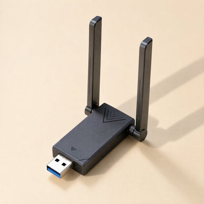 Wavebeam – Black USB adapter with dual upright antennas and a chevron pattern on the casing, on a beige surface