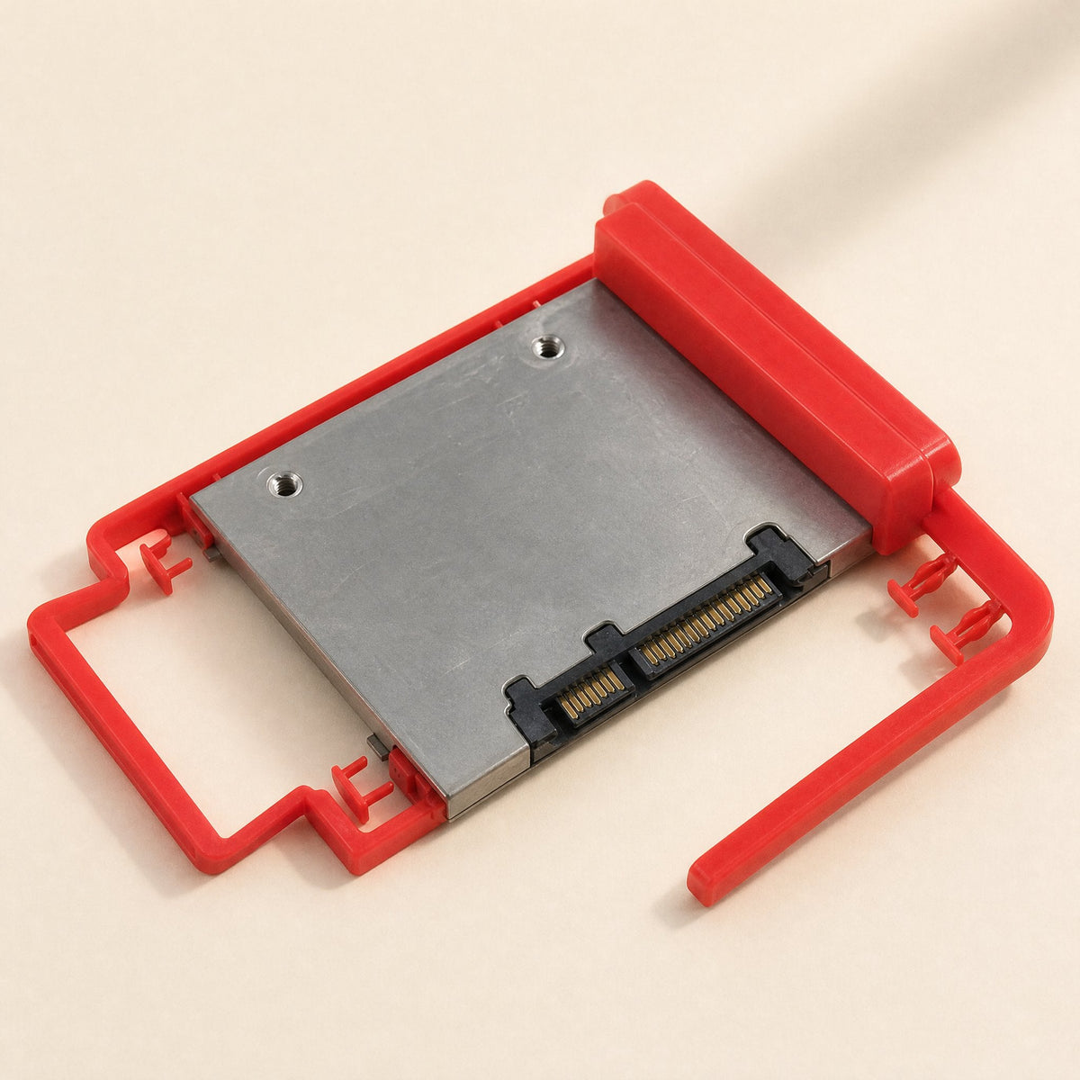 Driveclip – Angled view of the red bracket with an SSD mounted, one side arm swung open and the pegs visible