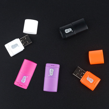 Memport – Five USB card readers in white, black, pink, purple and orange, some with caps removed, on a dark surface