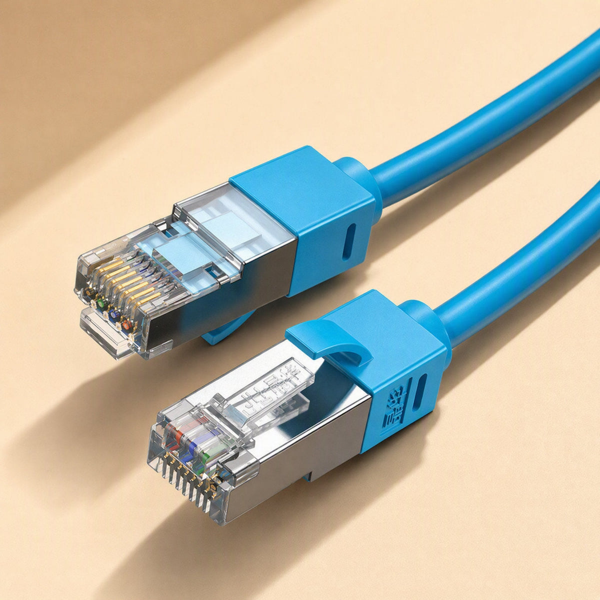 Shieldlink Cat6 network cable with blue boots and metal-shielded RJ45 connectors, close-up on beige