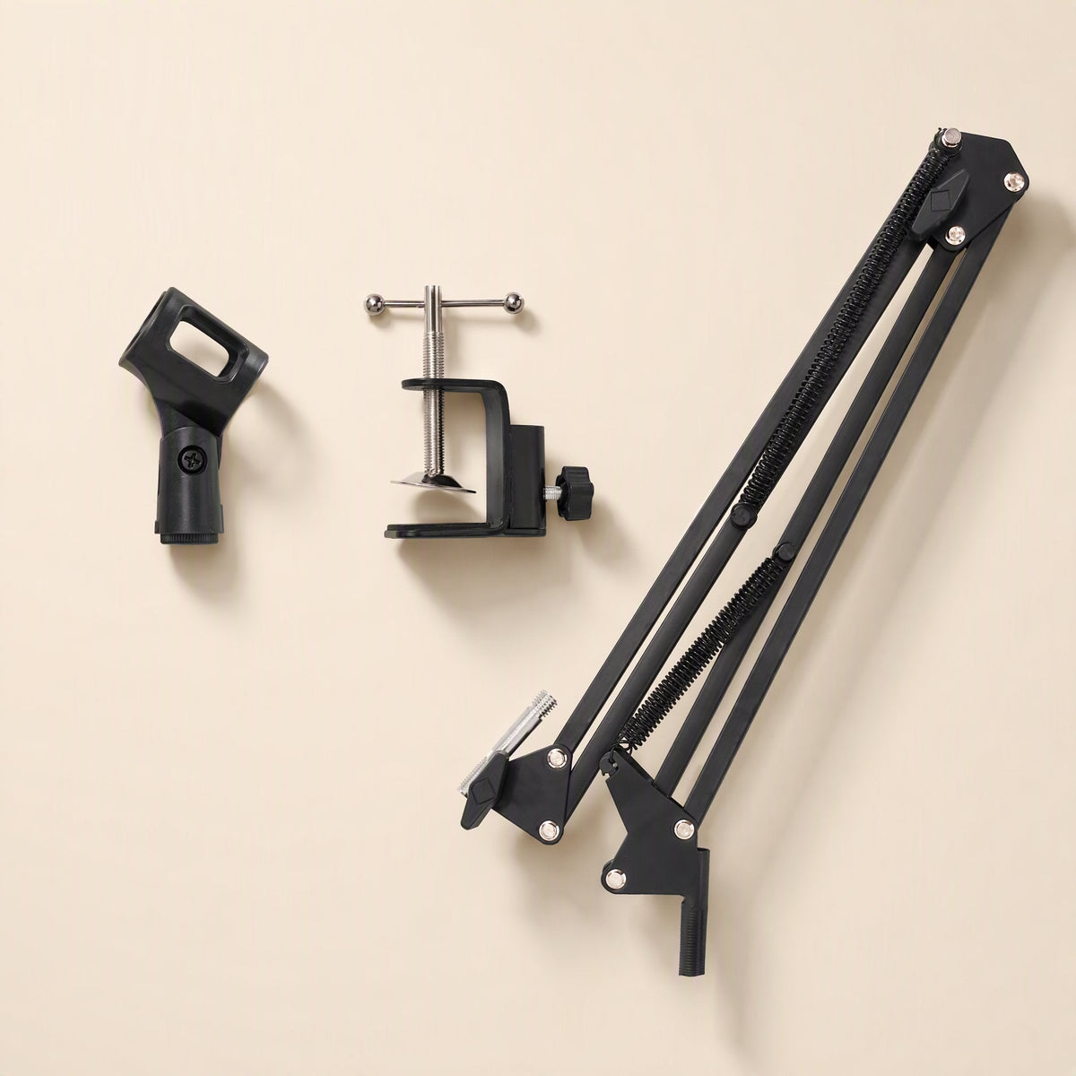 Reacharm Microphone Cantilever Bracket – boom arm, mic clip and C-clamp laid out separately on a beige surface