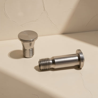 Hingehold – Two round-head hinge screws, one upright and one on its side, showing threads on a cream surface