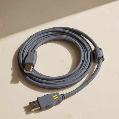 Printcord – Coiled gray USB cable with a ferrite bead near one end and yellow-striped USB-A plug in the foreground