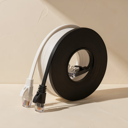 Flatlink Cat6 flat network cable in white and black coils, with RJ45 plugs, against a cream wall
