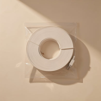 Flatlink – White flat network cable coiled inside a clear resealable bag, seen from above with the plug at the edge
