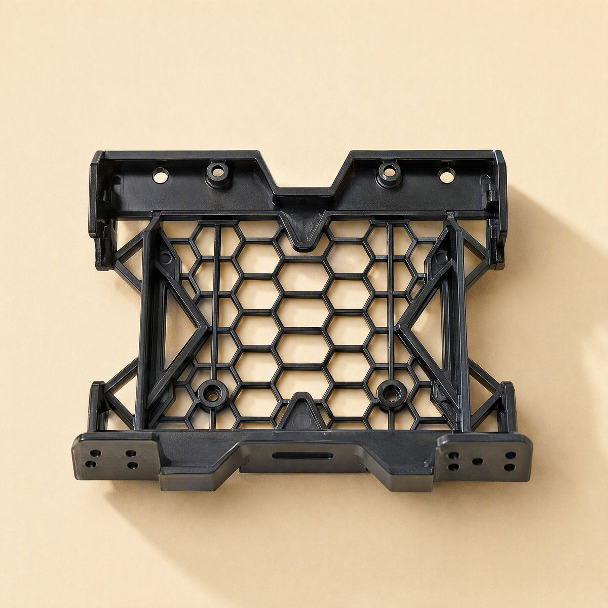 Drivecradle – Black drive bracket seen from the front at a slight angle, showing screw holes along the lower edge